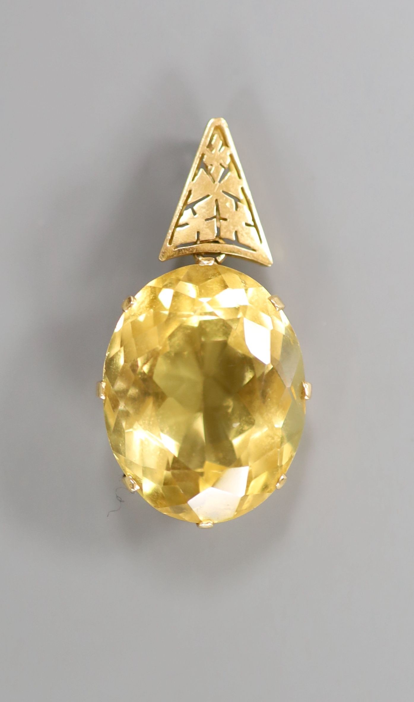 A yellow metal mounted oval citrine pendant, overall 39mm, citrine length 25mm, gross weight 10.8 grams.